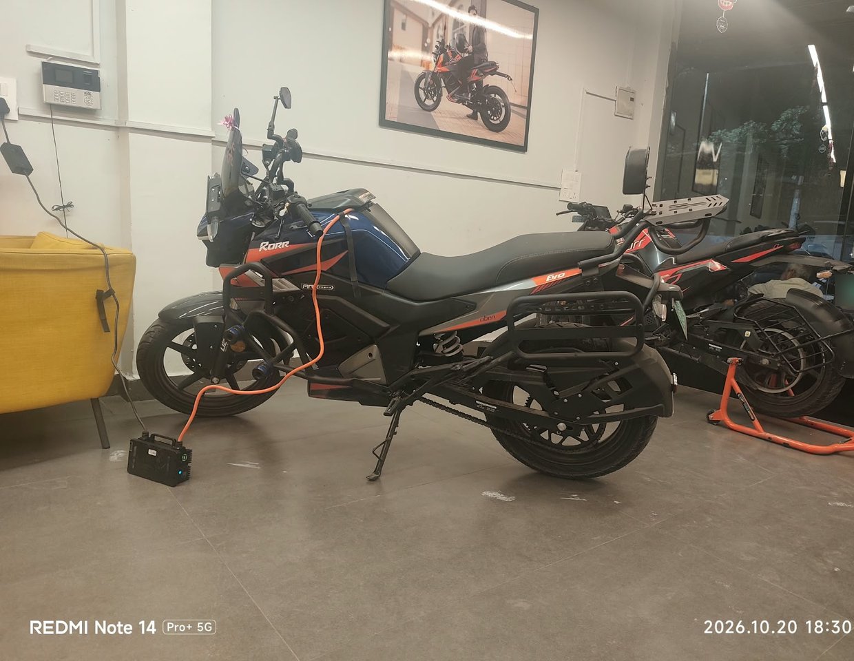 Owner's Oben Rorr EVO on charge at the Krishna Nagar showroom, 20 October 2026, 6:30 PM
